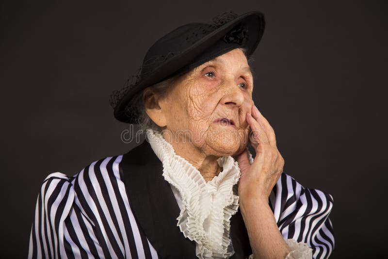 Παλαιό grandma σε ένα άσπρος-μαύρο ριγωτό σακάκι στοκ φωτογραφία
